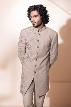 Fawn sherwani featuring floral hand embroidery. Paired with a pant. - Aza Fashions Fitted Bandhgala With Floral Embroidery In Traditional Drape, Fitted Embroidered Raw Silk Bandhgala, Embroidered Fitted Bandhgala In Raw Silk, Wedding Raw Silk Bandhgala With Floral Embroidery, Designer Fitted Bandhgala With Floral Embroidery, Bollywood Style Bandhgala With Floral Embroidery For Formal Occasions, Formal Bollywood Bandhgala With Floral Embroidery, Fitted Sherwani With Floral Embroidery For Designer Wear, Fitted Raw Silk Bandhgala With Intricate Embroidery