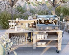 an outdoor kitchen with pots and pans on the table, next to potted plants