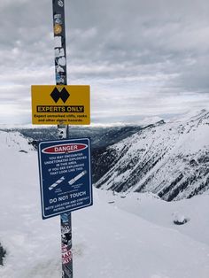 a sign on top of a snow covered mountain warning people to not touch the ground