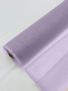 a roll of purple sheer fabric sitting on top of a table