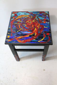 a small table that has been painted with different colors