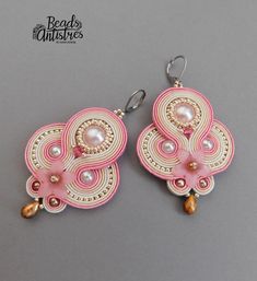 pink and white earrings with pearls on them