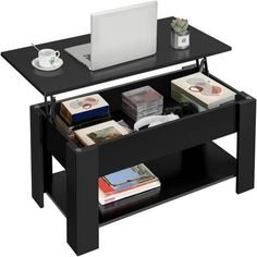 a black coffee table with two drawers and a laptop on it's side shelf