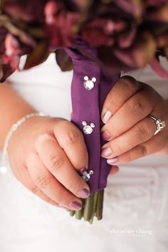 the bride is holding her wedding bouquet with flowers on it's wrist and wearing an elegant ring