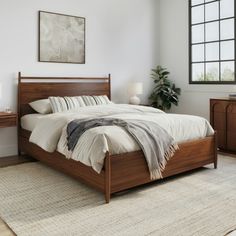 a bedroom with a bed, nightstands and rug on the floor in front of it