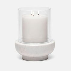 a white candle sitting in a glass holder