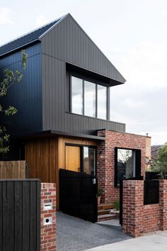 a modern house with brick walls and black gate