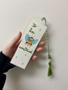 a hand holding a tag with a tassel attached to it that says tea bee confection