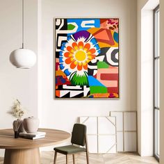 an abstract painting hangs on the wall above a dining room table with chairs and a vase