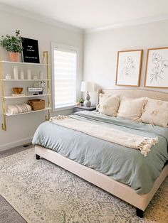 a bedroom with a bed, rug and two pictures on the wall above it's headboard