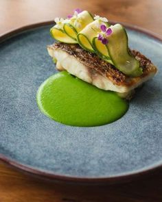 a blue plate topped with food and green sauce