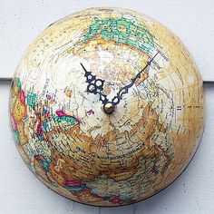 a wooden clock with a map on it's face