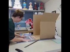 a woman is making something out of a cardboard box