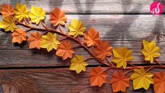 an orange and yellow paper flower on a branch