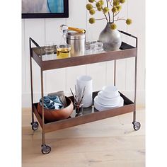 a metal serving cart with plates and cups on it