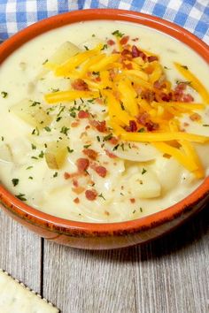 a bowl of potato soup with cheese and crackers