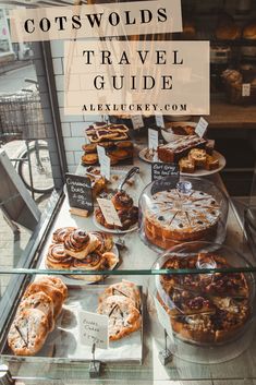 a table filled with lots of desserts and pastries on display in front of a window