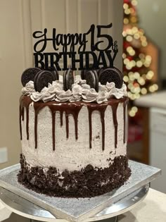 a birthday cake with oreo cookies and white frosting on top is sitting on a silver platter