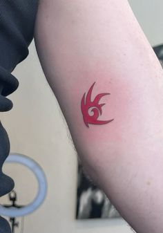 a man with a red tattoo on his arm