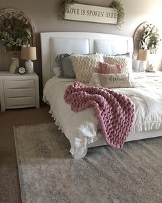 a white bed topped with pillows and blankets