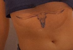 a woman's stomach with a cow skull drawn on the side and an arrow in the middle