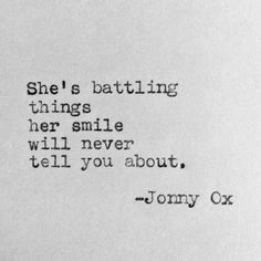 an old typewriter with the words she's battling things her smile will never tell you about