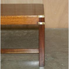 a close up of a wooden bench on a cement floor