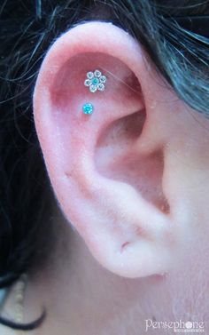 a close up of a person's ear with two piercings