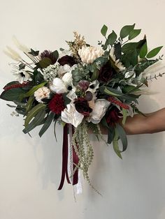 a bouquet of flowers is being held up against the wall