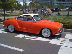 an orange and white car is parked on the street