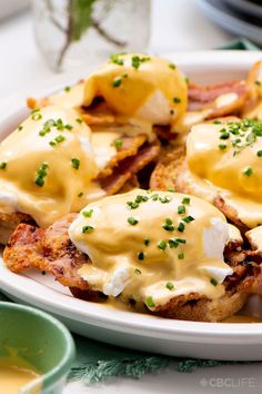 a white plate topped with eggs benedicts covered in hollandaise and mayonnaise