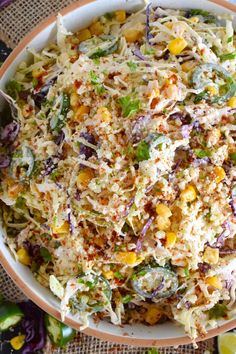 a white bowl filled with coleslaw and corn salad on top of a table