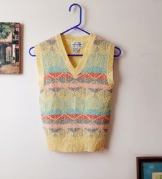 Layer Up. Argyle Sweater Vest. Vintage knit is Autumn-ready. Soft pastels: maize, aqua, pumpkin, rose, gray. Pullover has V-neckline, rib-knit accents. Spike your Autumn silks, tweeds and oxfords. Beneath a blazer for subtle color pop. 100% Acrylic. Size tagged S. Fits XS, S. Use measurements.  Hand-loomed in Korea. 1960's VINTAGE Chest width: 28-32" Shoulder: 14"  Length: 20" Vintage Multicolor Sweater Vest For Winter, Multicolor Vintage Sweater Vest For Winter, Retro Winter Sweater Vest, Fitted Retro Knit Sweater Vest, Retro Fitted Knit Sweater Vest, Fitted Vintage V-neck Sweater Vest, Vintage Fitted V-neck Sweater Vest, Fitted Vintage Sweater Vest With V-neck, Affordable Multicolor V-neck Sweater Vest