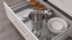 an open drawer with dishes and utensils in it