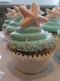 three cupcakes with blue frosting and starfish decorations