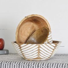 two bowls with spoons in them and an apple on the table next to it