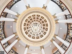 an ornate ceiling with chandelier and columns in a building's center dome