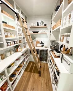 a kitchen with white shelving and wooden flooring