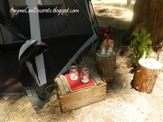 an open tent next to two wooden crates with cups on them and a red napkin