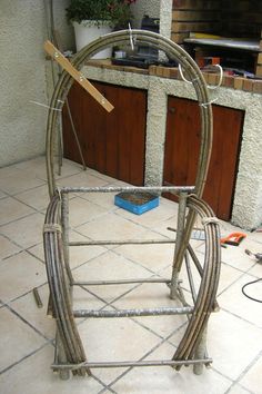 a large metal object sitting on top of a tile floor next to a wall and potted plant