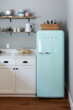 a blue refrigerator sitting in the middle of a kitchen