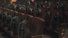 many dogs are sitting in the middle of an empty theater seat with their mouths open