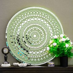 a green plate sitting on top of a table next to a potted plant