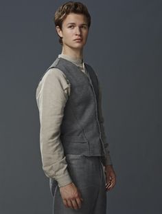 the young man is dressed in grey clothing