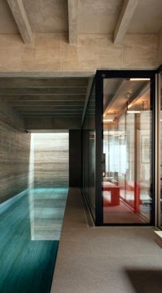 an indoor swimming pool in the middle of a room with glass doors on both sides