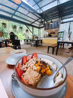 a bowl filled with lots of food on top of a wooden table in a restaurant