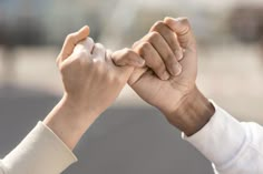 two people holding hands in the air