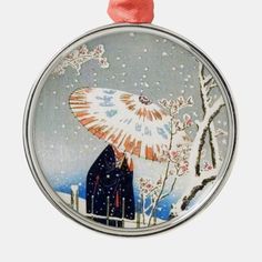 a round ornament with an image of two people under an umbrella in the snow