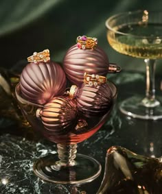 two wine glasses filled with different colored ornaments