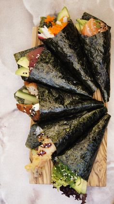 sushi rolls are arranged on a cutting board